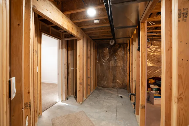Framed interior construction with exposed wood studs, concrete flooring, and visible ductwork