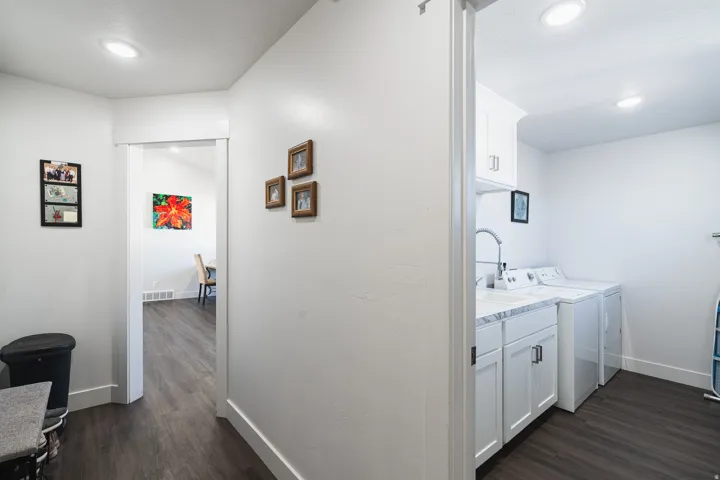 Dedicated laundry area featuring white cabinetry, a sink with a gooseneck faucet, and a light-toned countertop