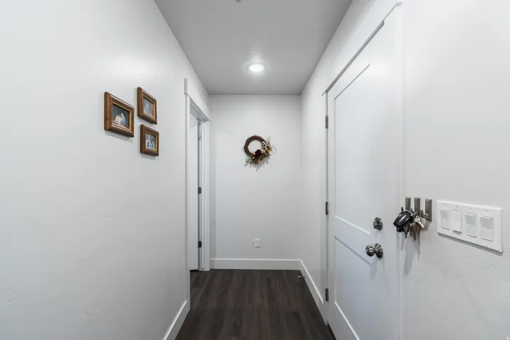 Wood-finish flooring with white trim and a white interior door