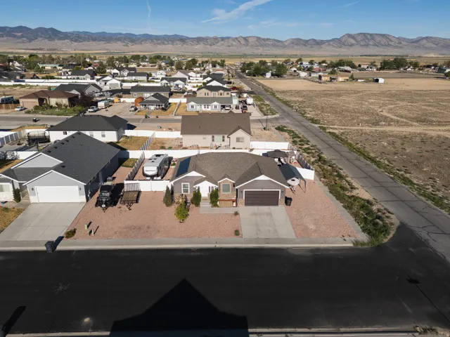 Ranch-style residence featuring a prominent front-facing garage, gravel landscaping, and a fenced side yard