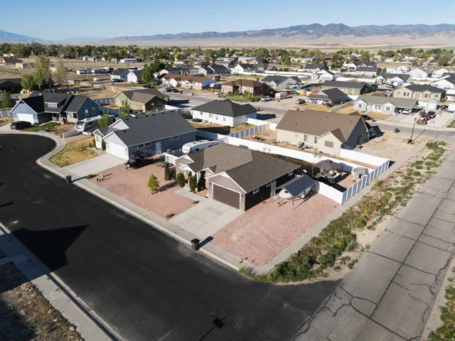 Newly constructed residence featuring a neutral exterior, a single-car garage, and a white privacy fence