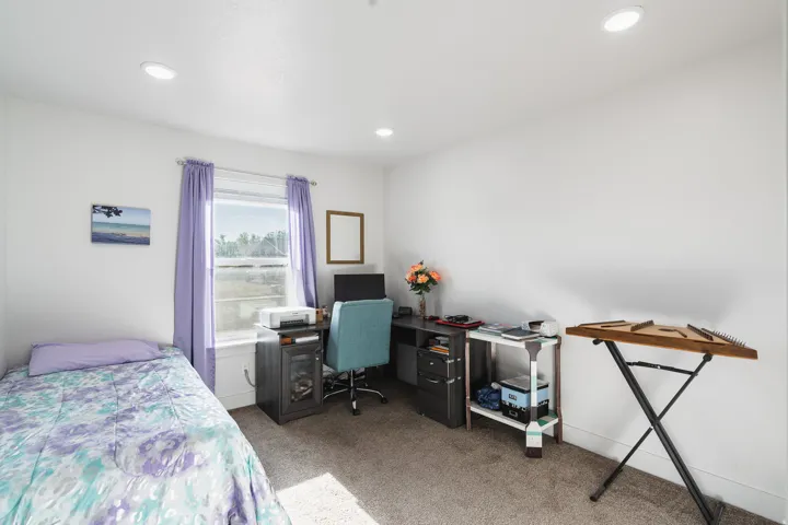 Recessed lighting, white walls, carpeted flooring, and a window with trim