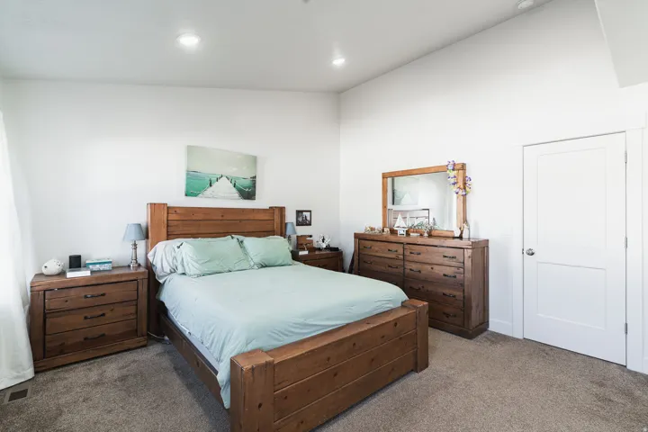 Recessed lighting, vaulted ceiling, white walls, paneled door, and carpeted flooring