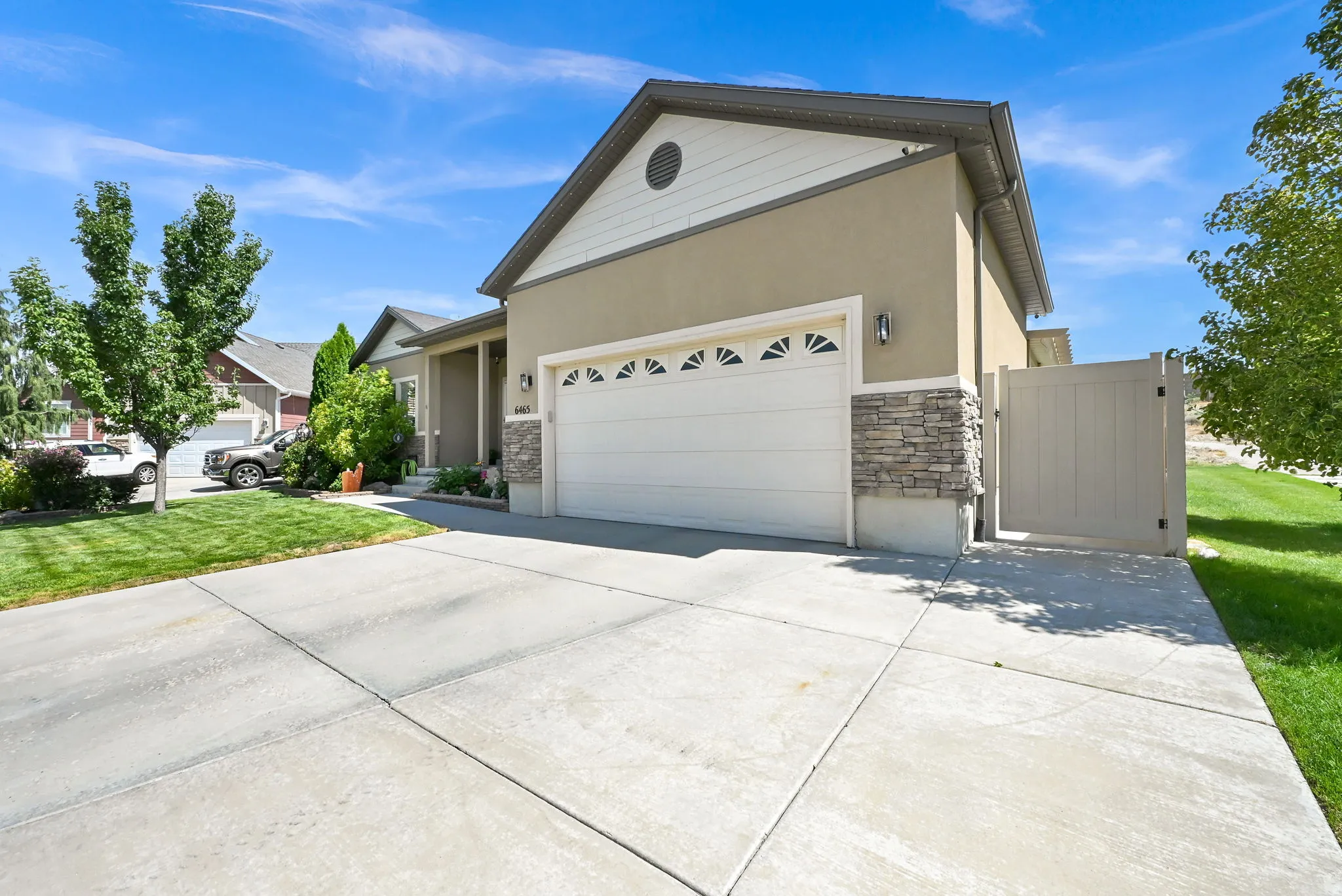 Exterior featuring stucco siding, stone accents, and a concrete driveway