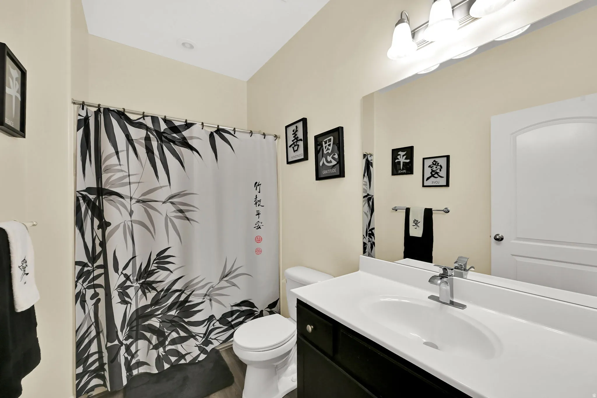 Recessed ceiling light, vanity with integrated sink, chrome faucet, wall-mounted mirror, and a wall-mounted light fixture