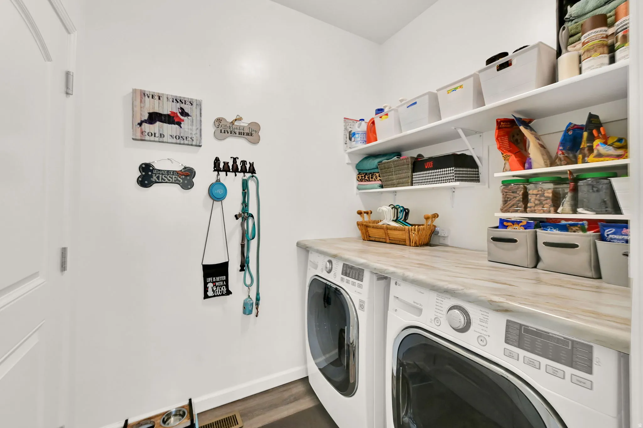 LAUNDRY ROOM/MUDD ROOM. Next to garage and kitchen. Built-in open shelving, light-toned countertop, and integrated washer and dryer units