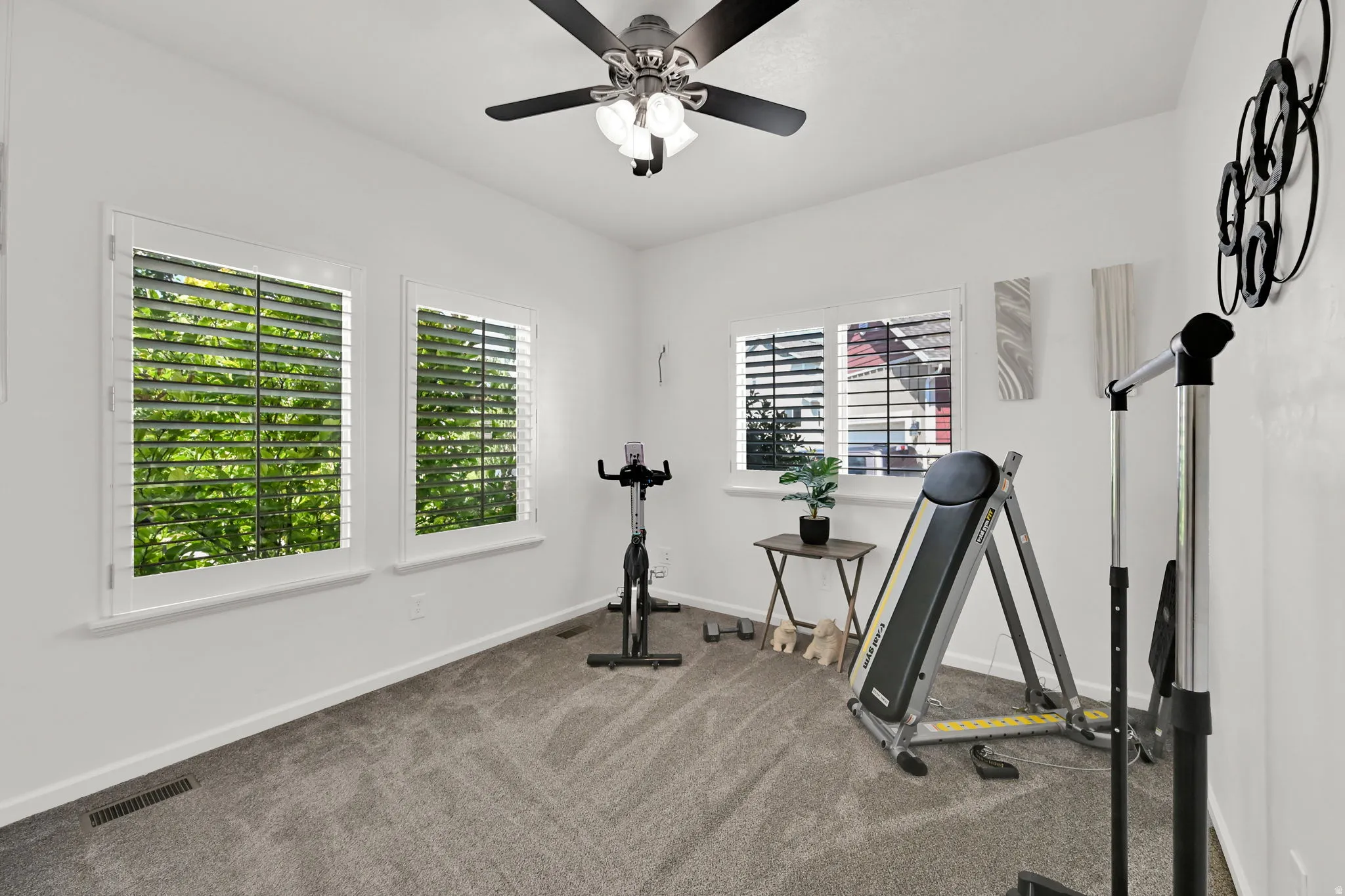 MAIN FLOOR BEDROOM. Could be used as an office. Recessed lighting, ceiling fan, plantation shutters, gray carpeting, and white walls