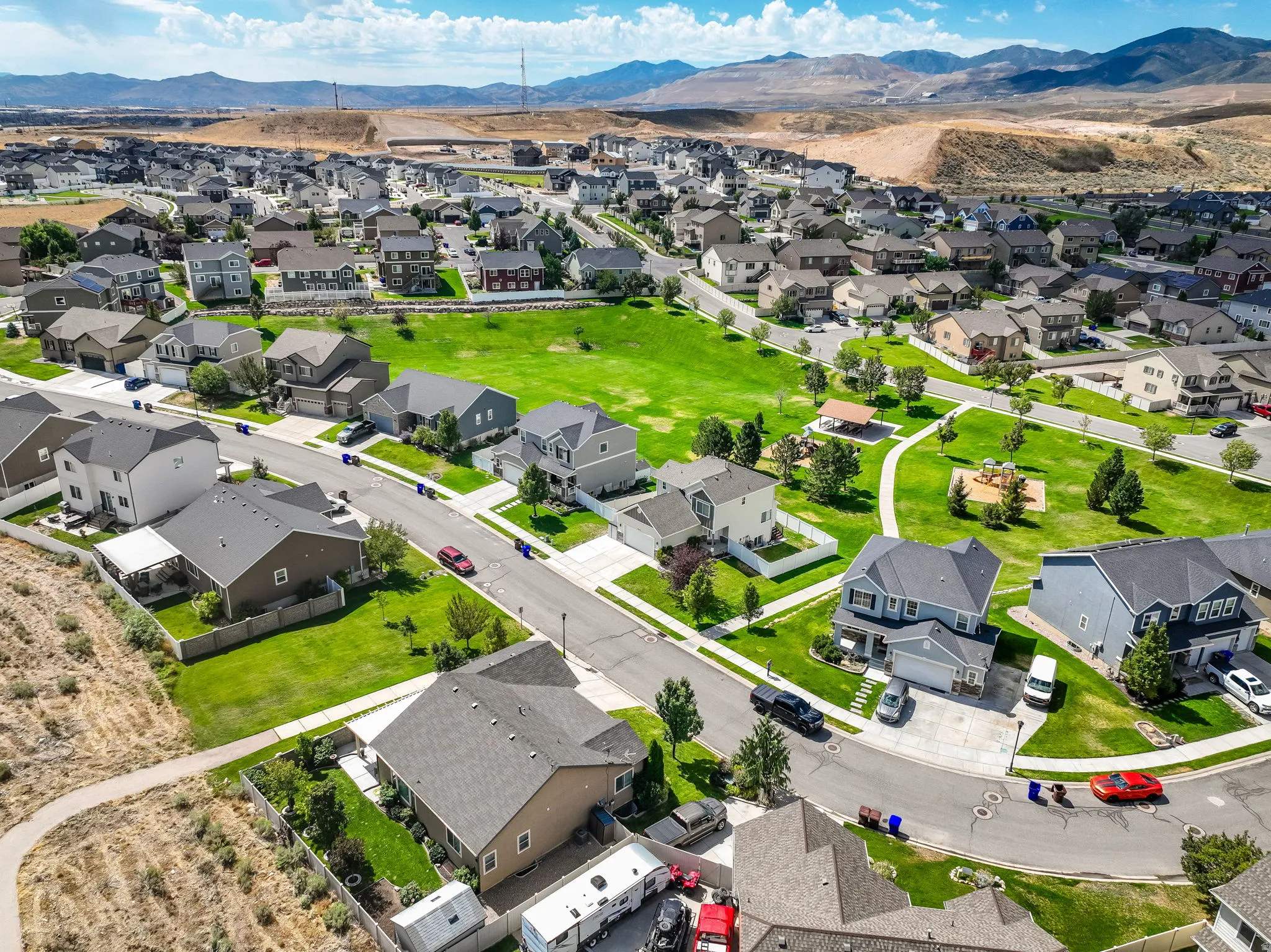 Residential development with numerous homes, paved streets, and a central green space