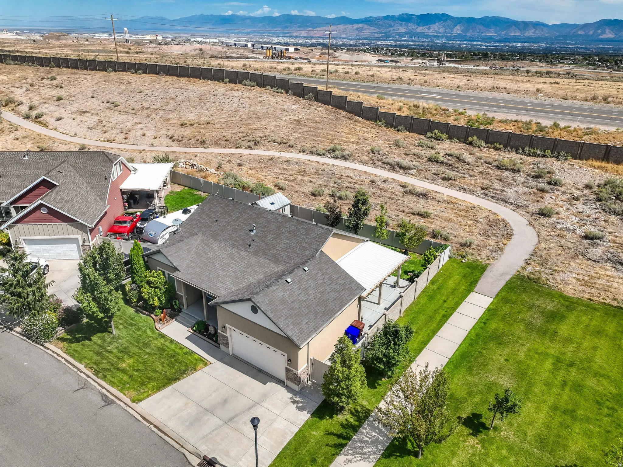 Suburban residence featuring an attached garage, paved driveway, and covered patio