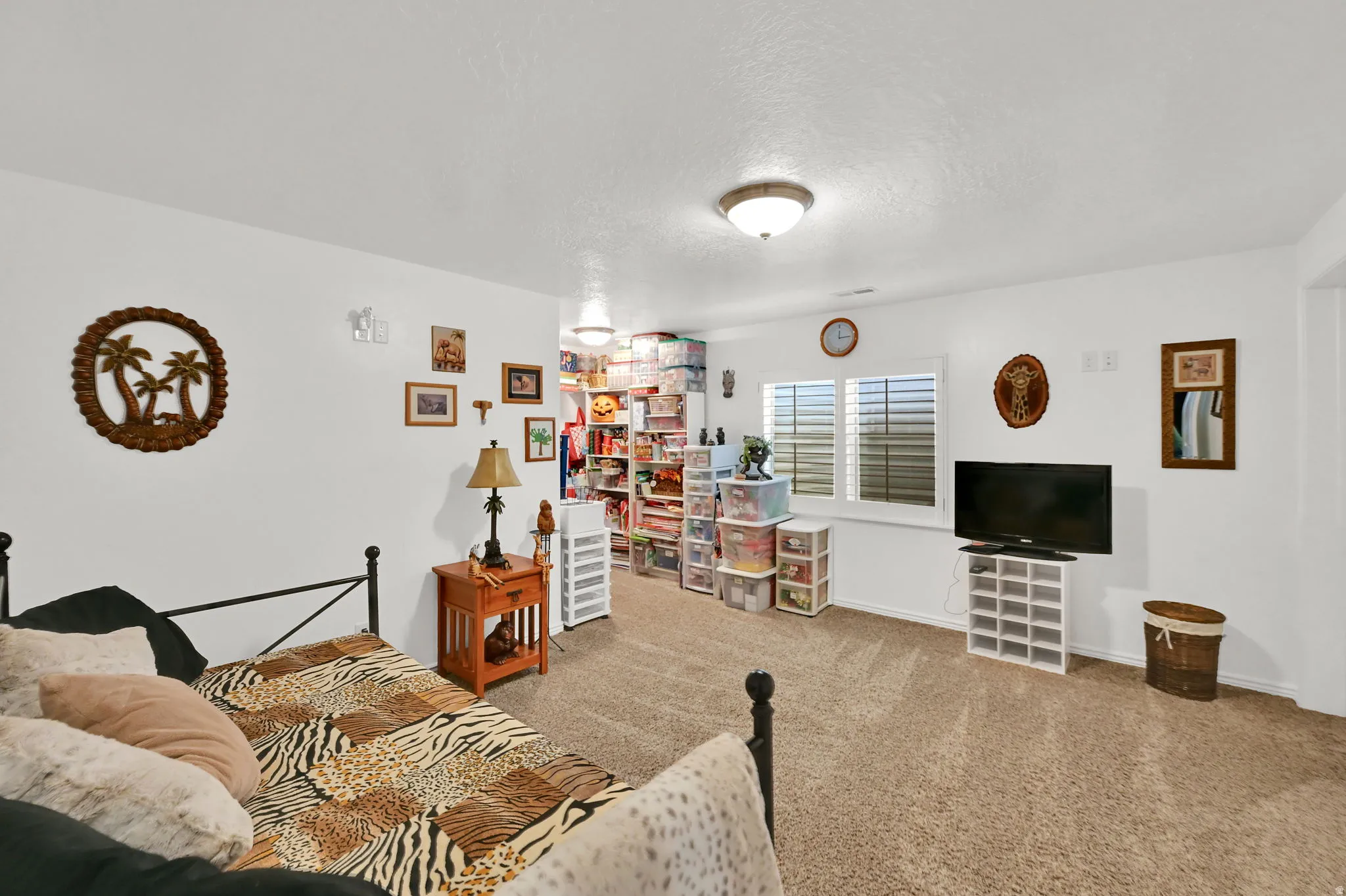 BASEMENT BEDROOM. Recessed window with horizontal blinds, overhead ceiling light fixture, and textured carpeting