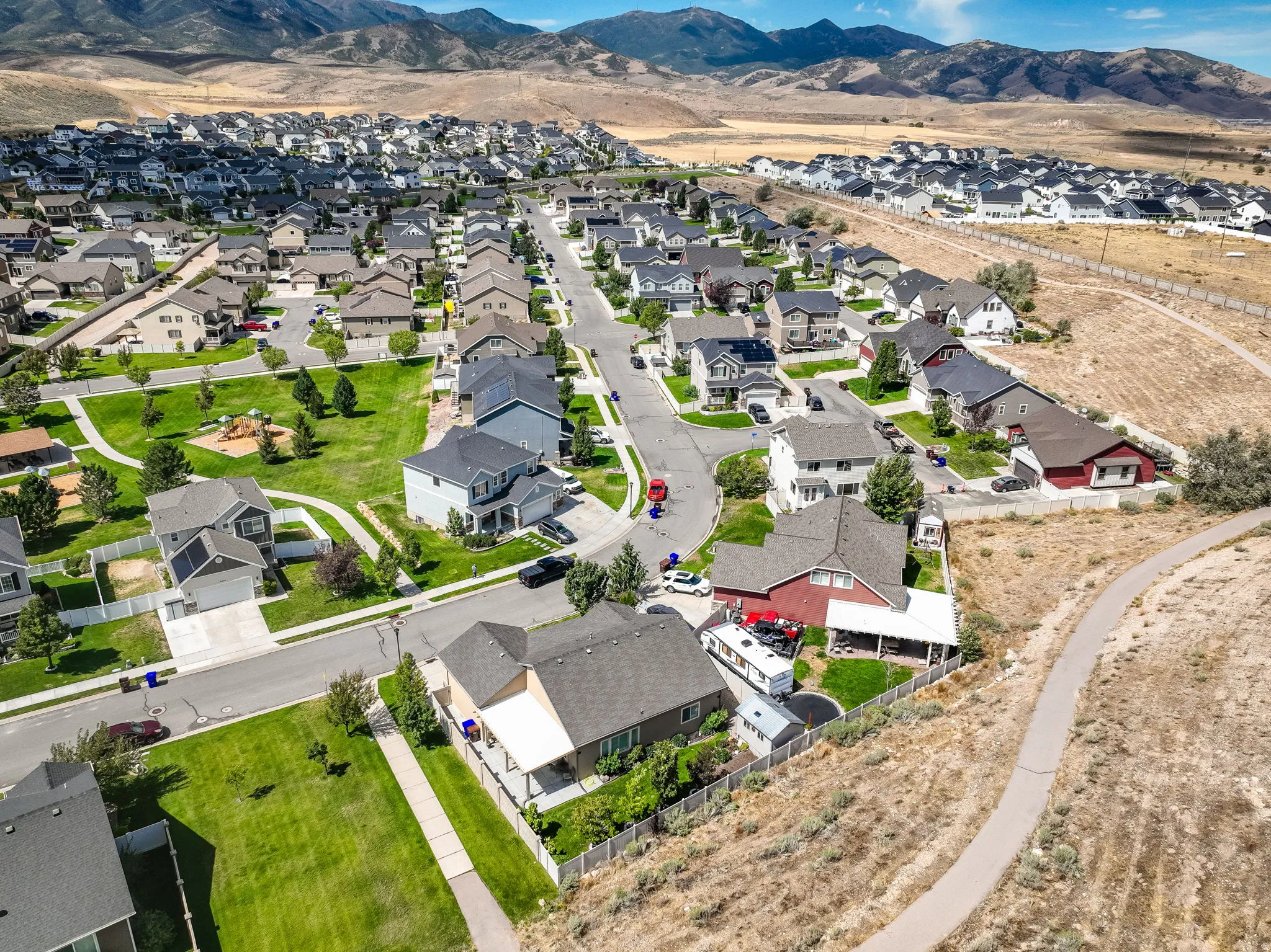 Community featuring paved streets, mature trees, manicured green spaces, and mountain scenery