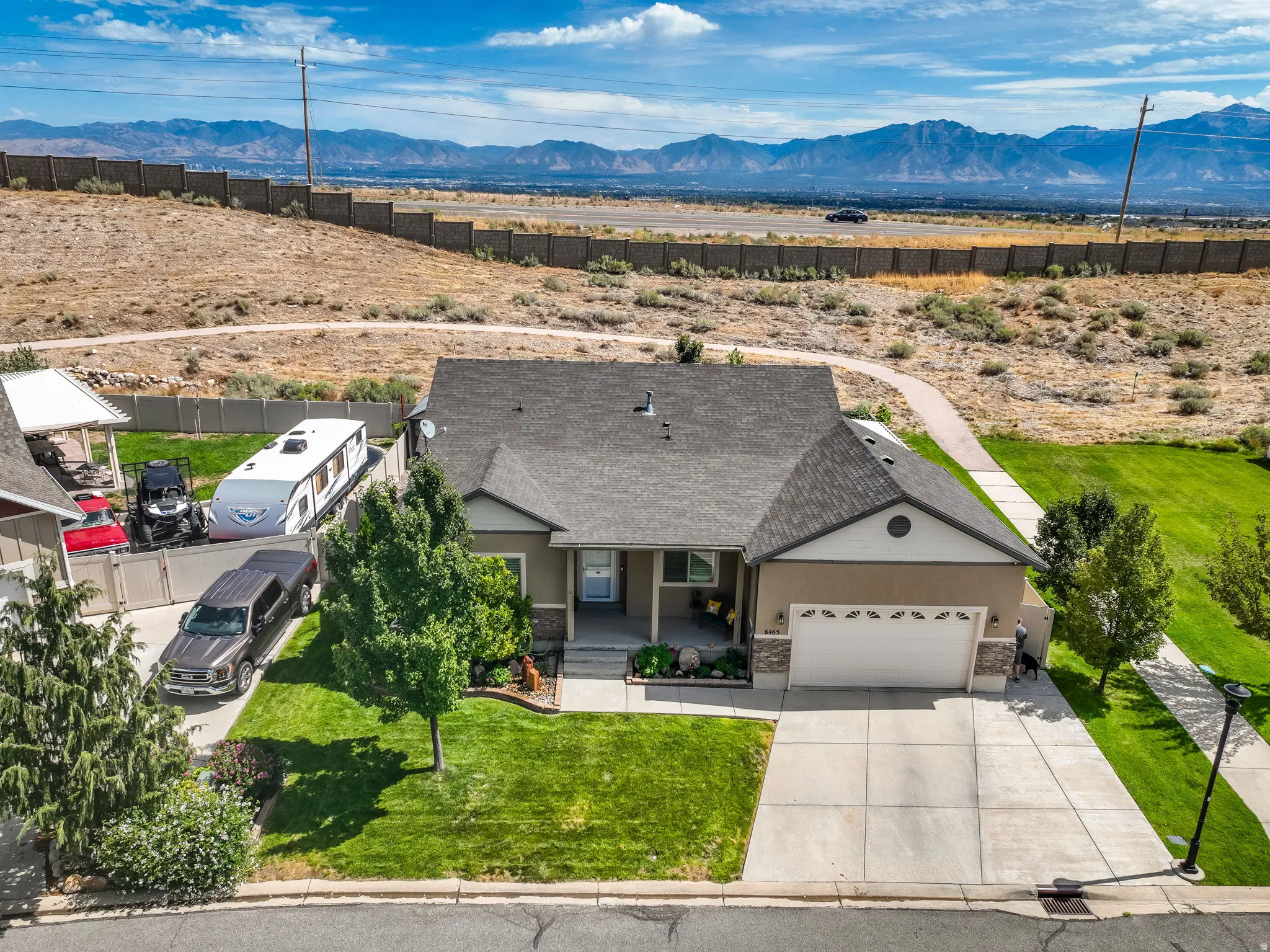 Warm exterior with a two-car garage, concrete driveway, and front lawn
