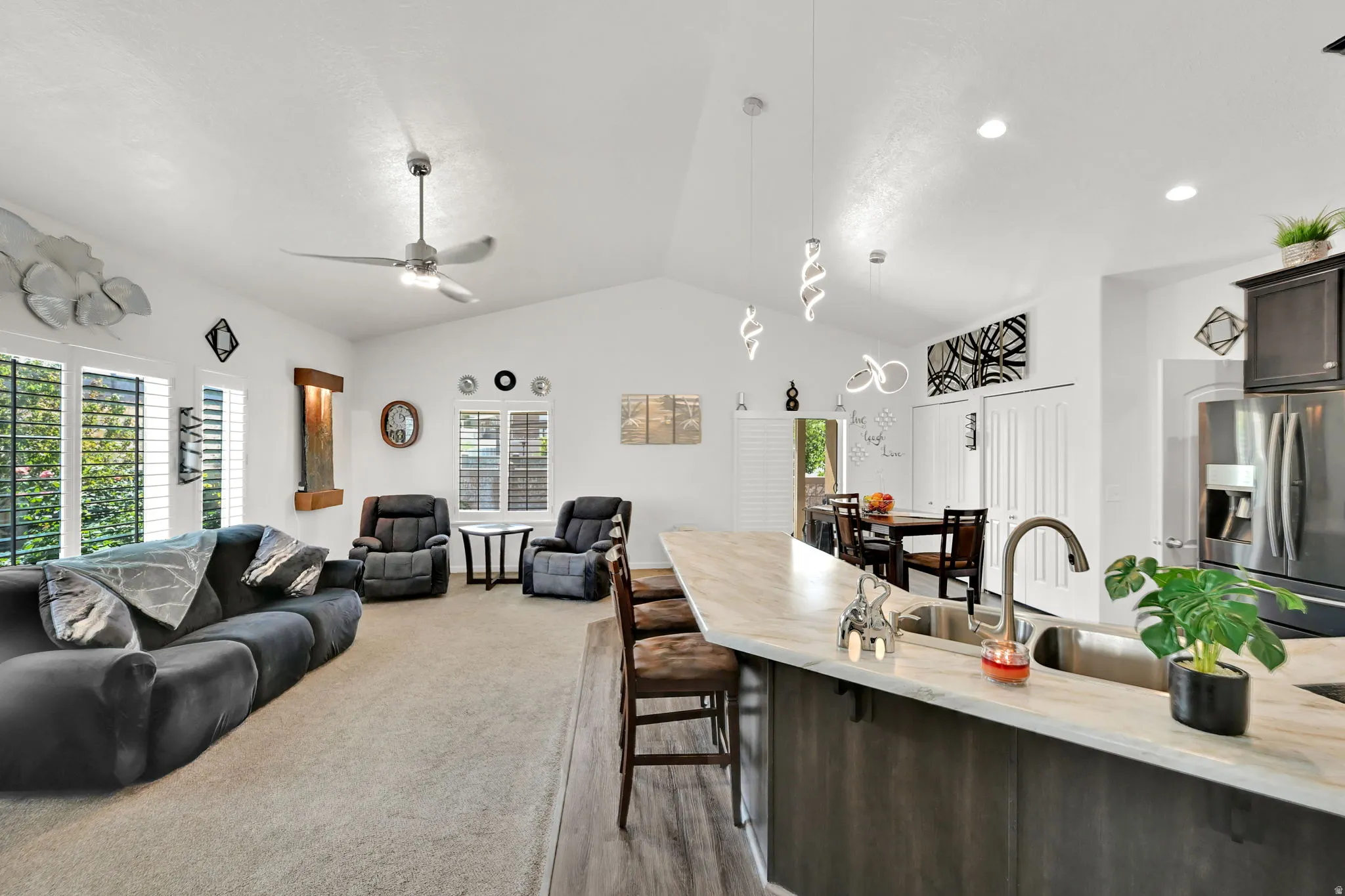 Vaulted ceilings, recessed lighting, and a ceiling fan enhance the living space