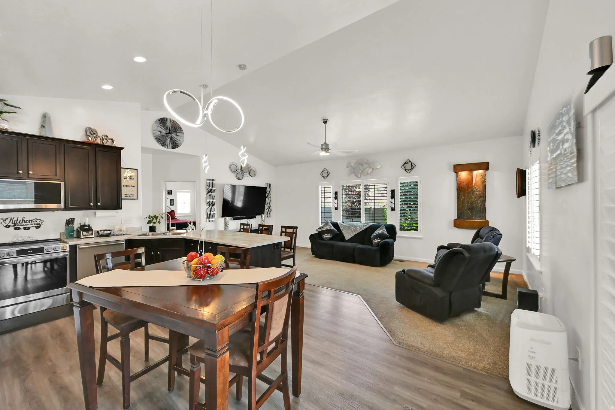 KITCHEN/DINING AREA/LIVING ROOM. Vaulted ceilings with a ceiling fan, recessed lighting, wood-finish flooring, and dark wood-finish cabinetry