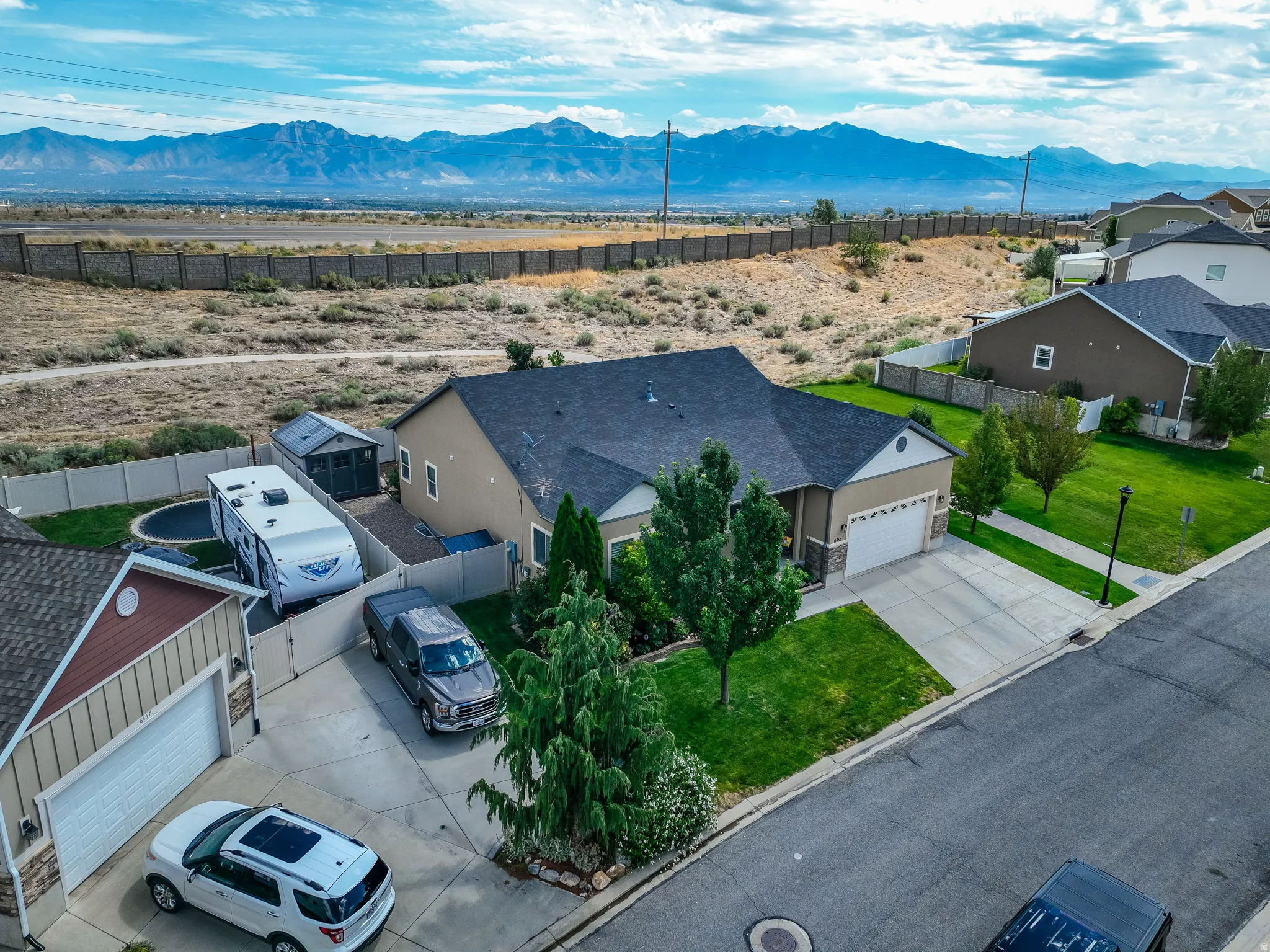 Single-story residence featuring a two-car garage, concrete driveway, and a front lawn with established landscaping