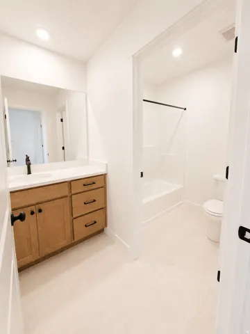 Wood-finish vanity with a white countertop and rectangular sink
