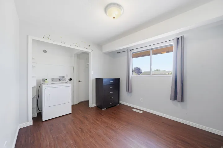 Wood-finish flooring with light gray wall paint and a built-in laundry area