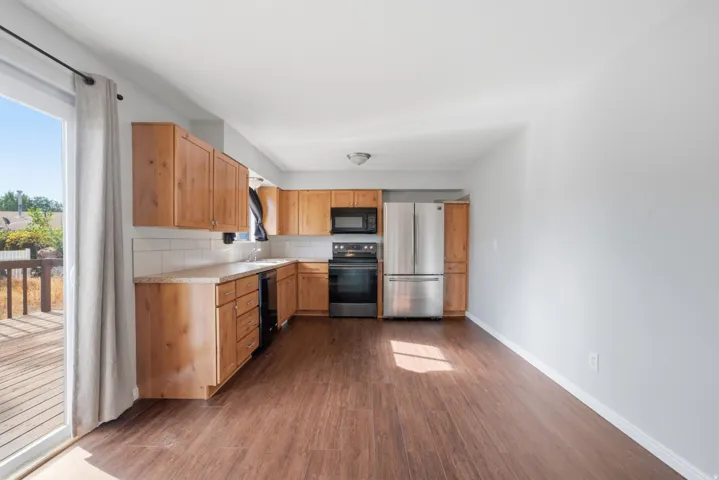 Kitchen featuring wood cabinetry, stainless steel appliances, and wood-finish flooring