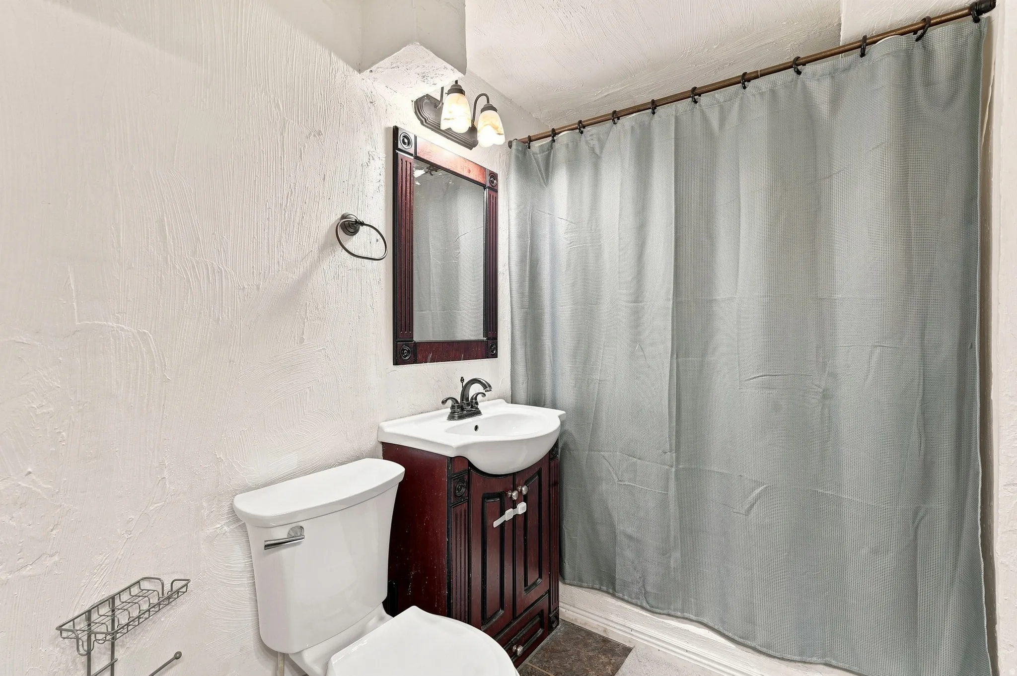 White toilet with a dark wood-finish vanity