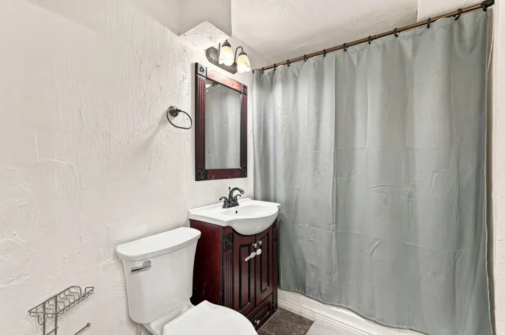 White toilet with a dark wood-finish vanity