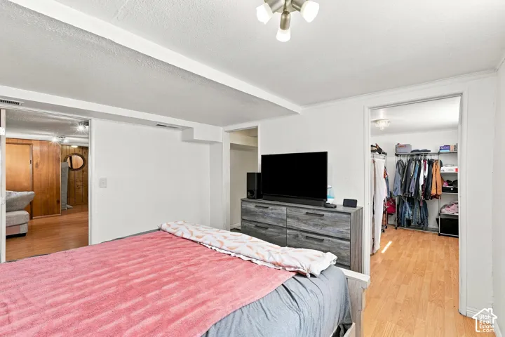 Interior space featuring white walls, light wood-finish flooring, and a multi-bulb flush-mount ceiling fixture