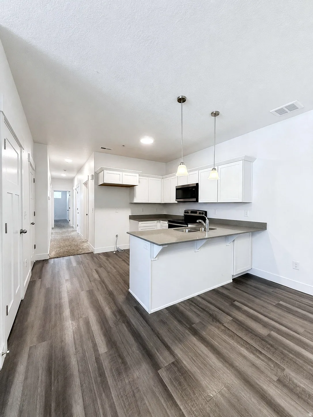 Kitchen featuring white cabinetry, a kitchen island, and stainless steel appliances