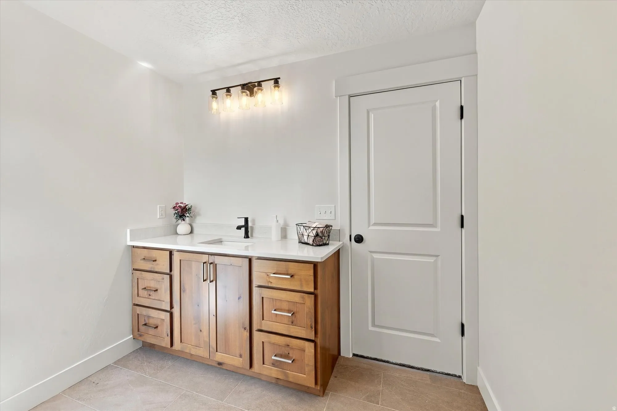 Wood-finish vanity with ample storage, integrated sink, and quartz countertop