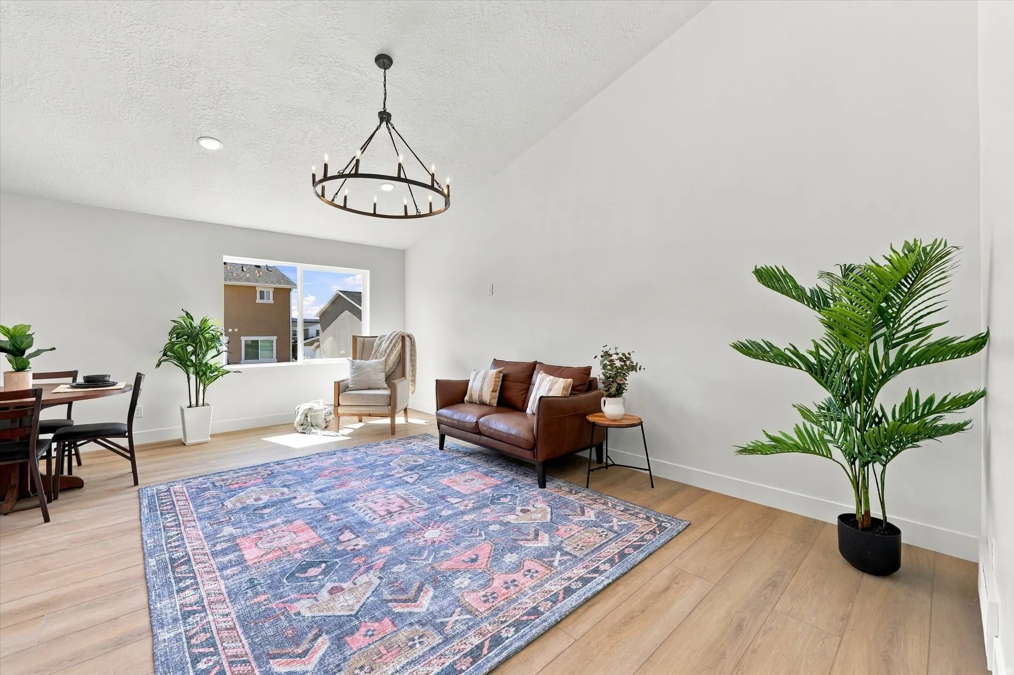 Vaulted ceiling with an iron chandelier, recessed lighting, wood-finish flooring, and white walls