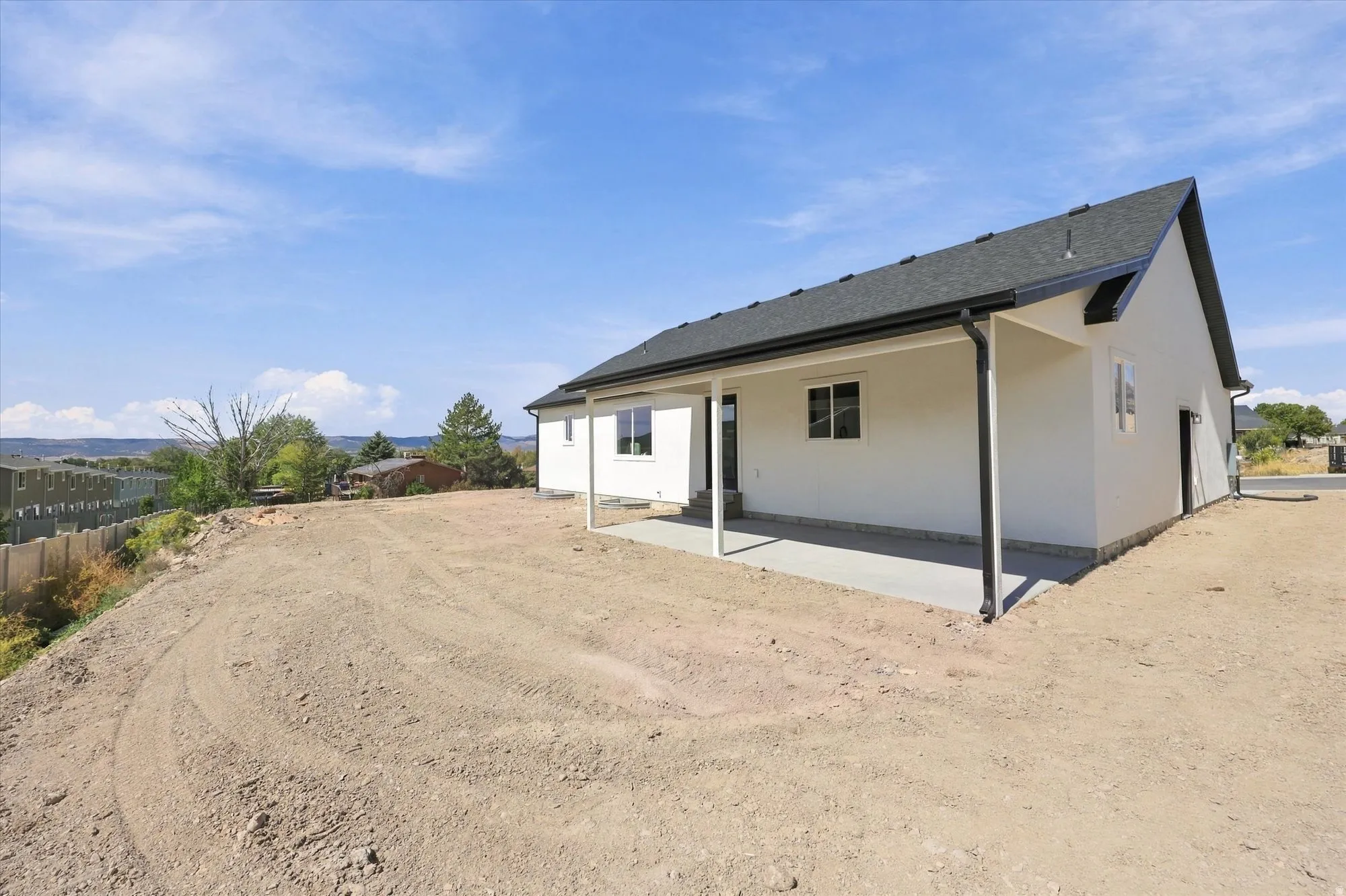 White stucco exterior with a dark asphalt shingle roof
