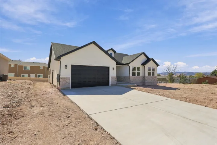 Contemporary exterior with a dark-pitched roof, white siding, and stone accents