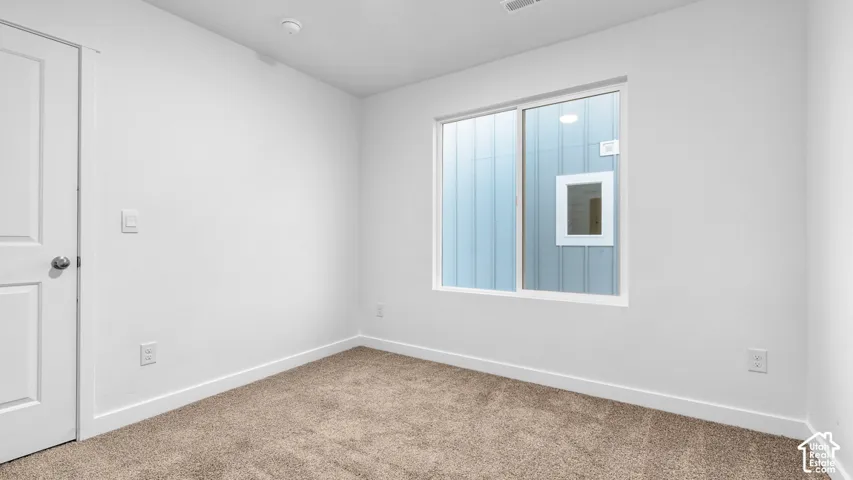 Neutral white wall finish, white trim, light brown carpet, and a white framed window