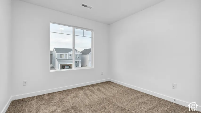Neutral carpet flooring, white painted walls, white trim, and a white framed window