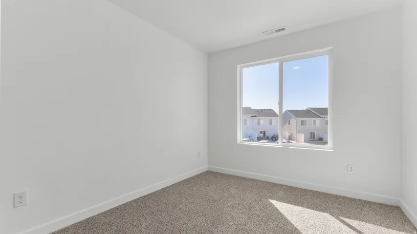 Carpeted flooring, white walls, and a large window with white trim