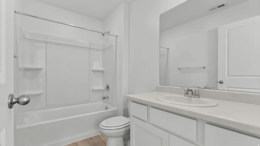 White vanity with an integrated sink, polished chrome faucet, and expansive wall-mounted mirror