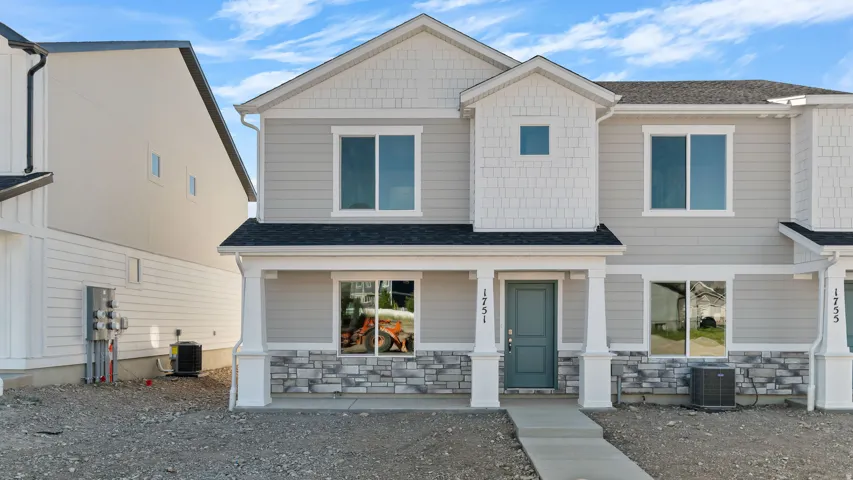 Two-story exterior with light gray siding, white shingle accents, a dark gray roof, and a teal front door