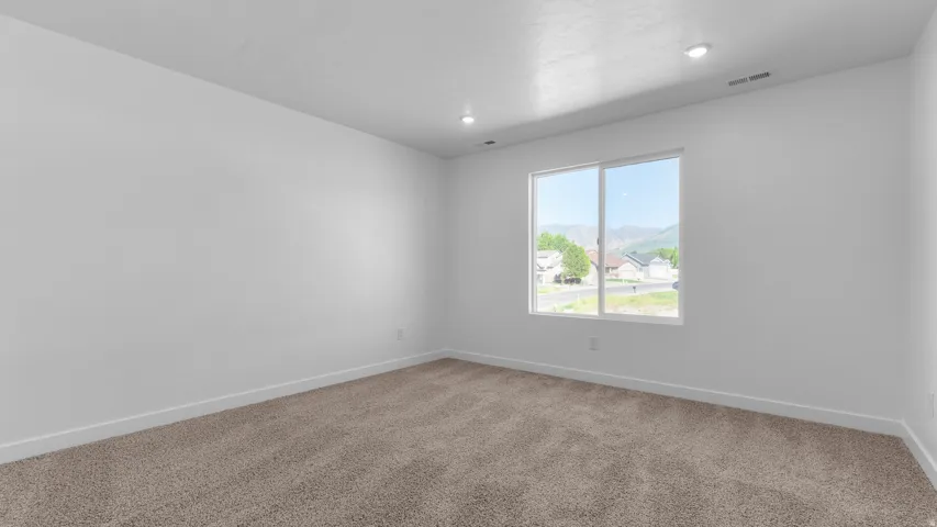 Carpeted flooring, white walls, recessed lighting, and a large window
