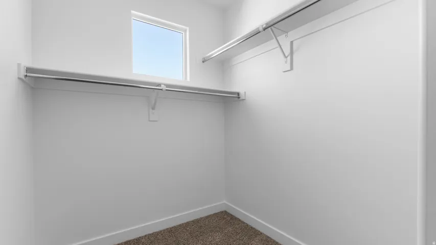 Built-in shelving and chrome hanging rods with a window for natural illumination