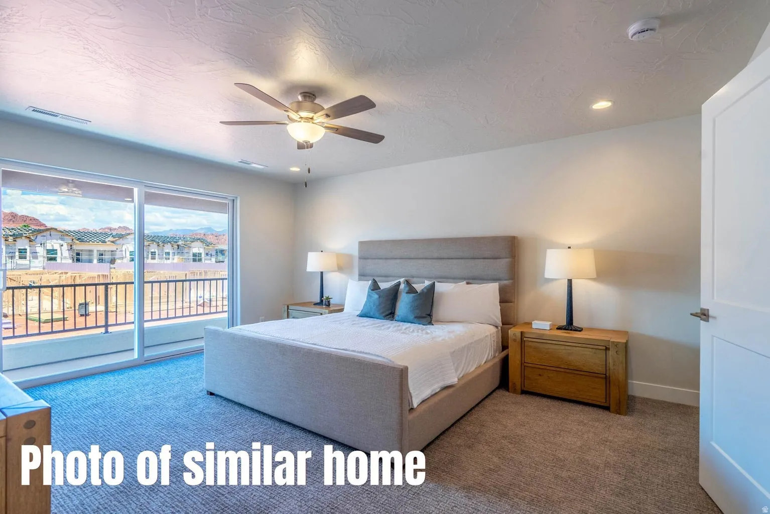 Sliding glass door leading to a private balcony with metal railing, ceiling fan with integrated lighting, recessed lighting, and light-toned carpet flooring