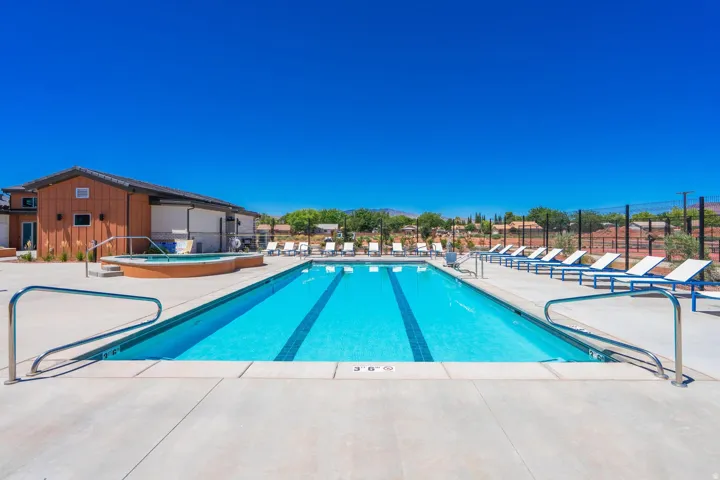 Outdoor swimming pool with integrated lane lines, concrete decking, and an adjacent hot tub