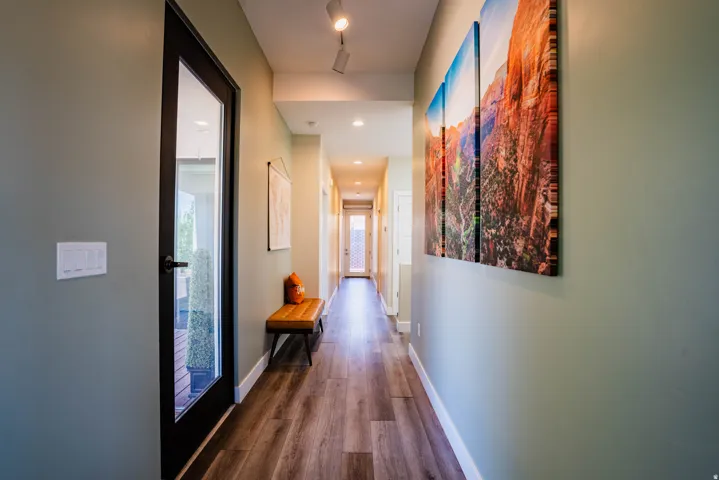 Hallway with wood-finish flooring, recessed lighting, and a full-light panel door