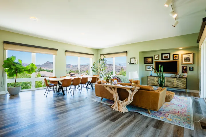 Expansive interior with wood-finish flooring, a wall of large windows, recessed lighting, and track lighting