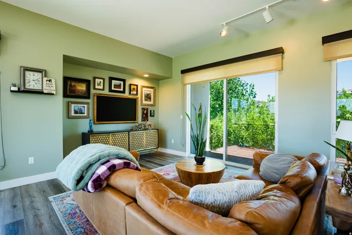 Recessed entertainment niche, track lighting, wood-finish flooring, sliding glass doors, and built-in shelving