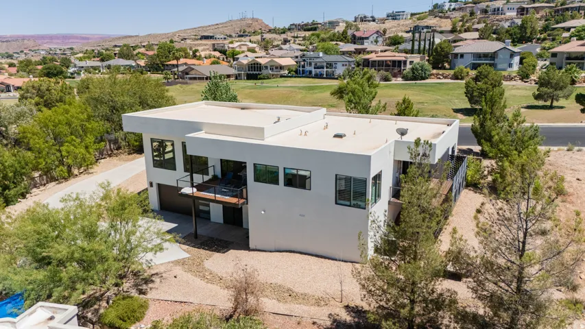 Modern architectural exterior with a flat roofline, integrated garage, and a raised exterior deck