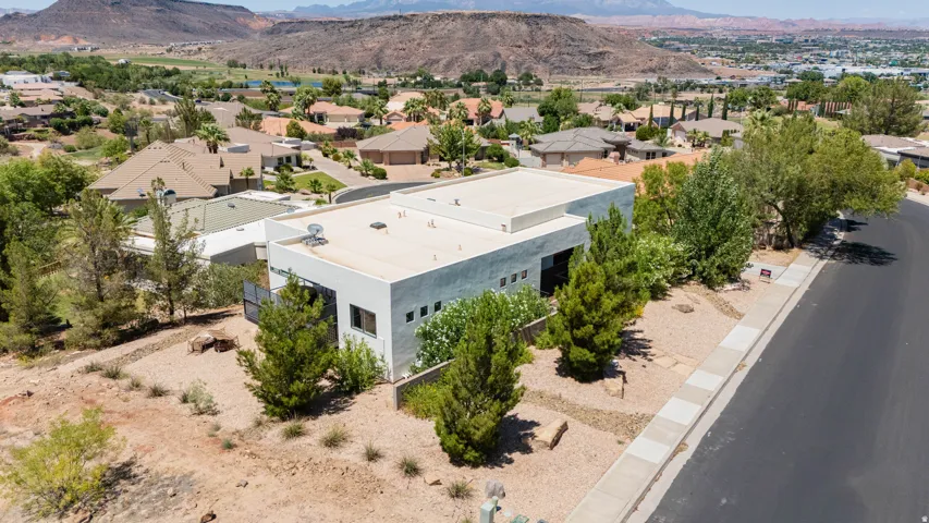 Contemporary architecture with a flat roofline, xeriscaped front yard, and a paved street