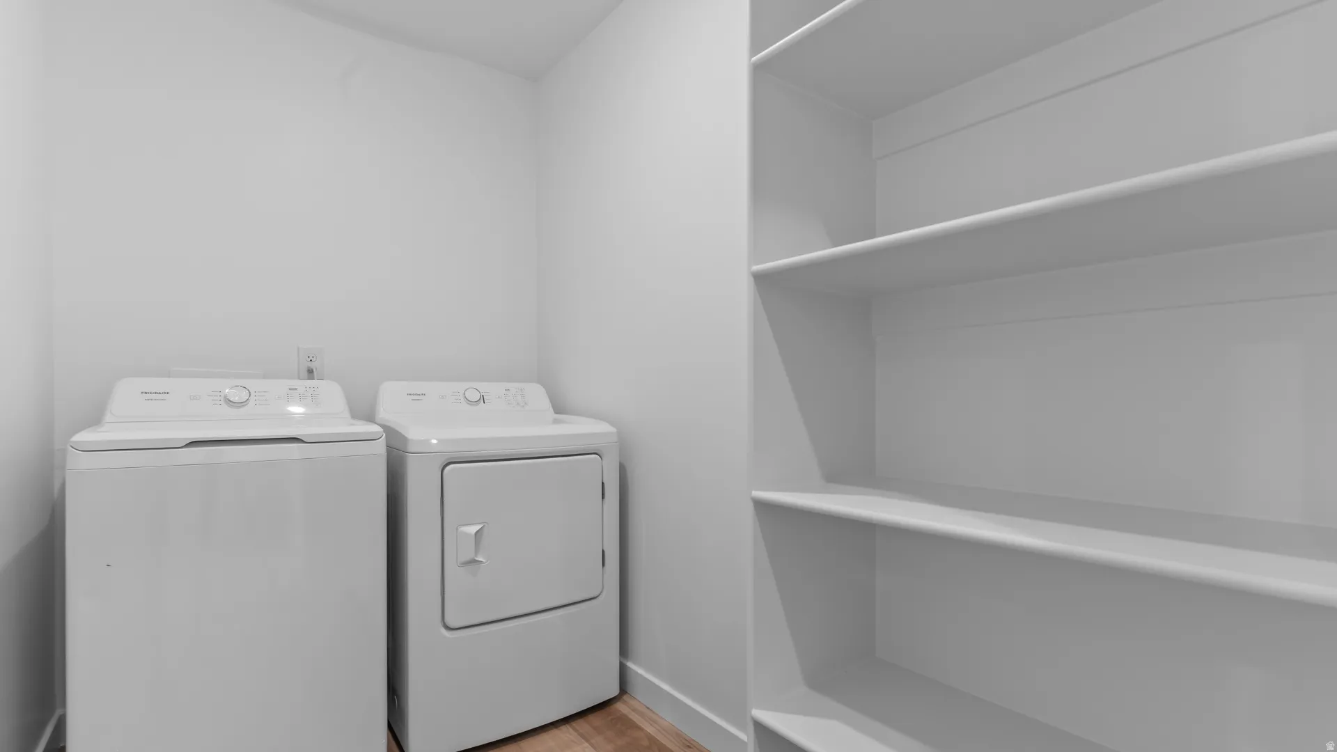 Laundry area featuring a top-load washer, front-load dryer, and built-in shelving