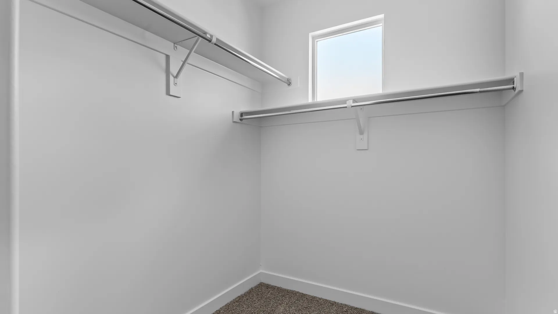 Built-in closet shelving and hanging rods with a window