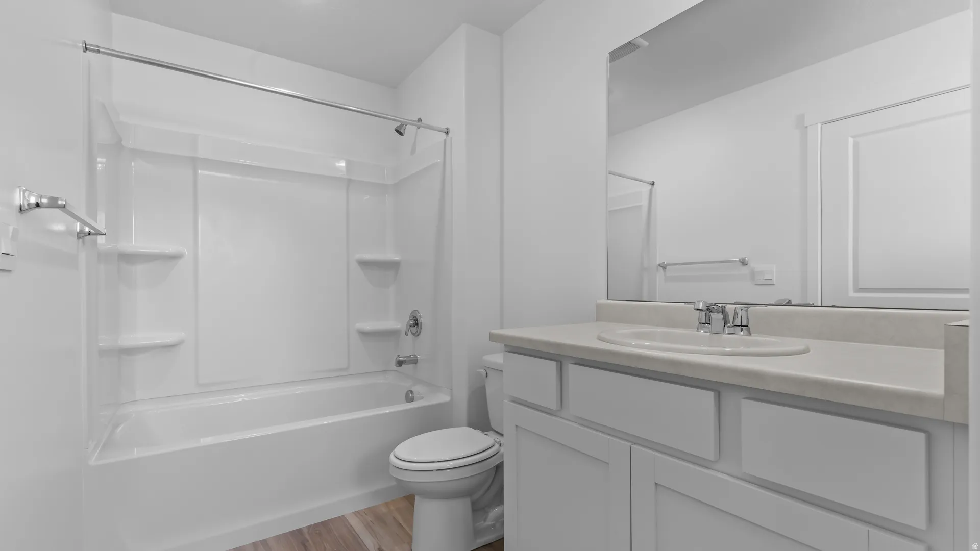White vanity with an integrated sink, polished chrome faucet, and expansive mirror
