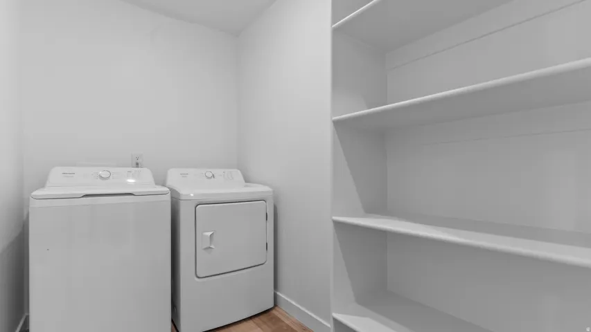 Laundry area featuring a top-load washer, front-load dryer, and built-in shelving