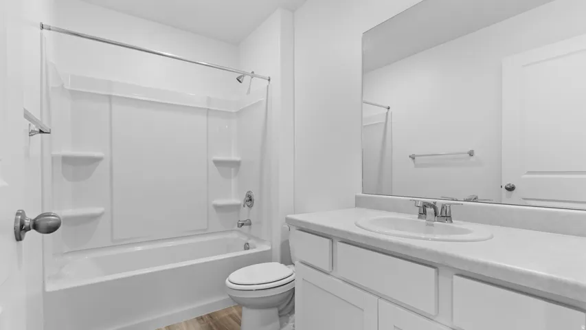 White vanity with an integrated sink, polished chrome faucet, and rectangular mirror