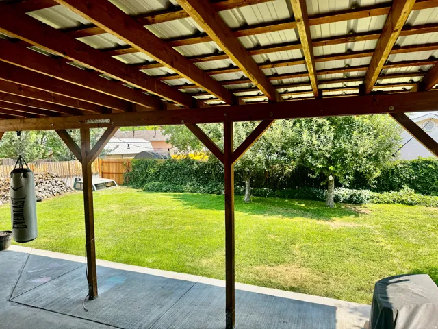 Covered patio with a wood beam structure and corrugated metal roof